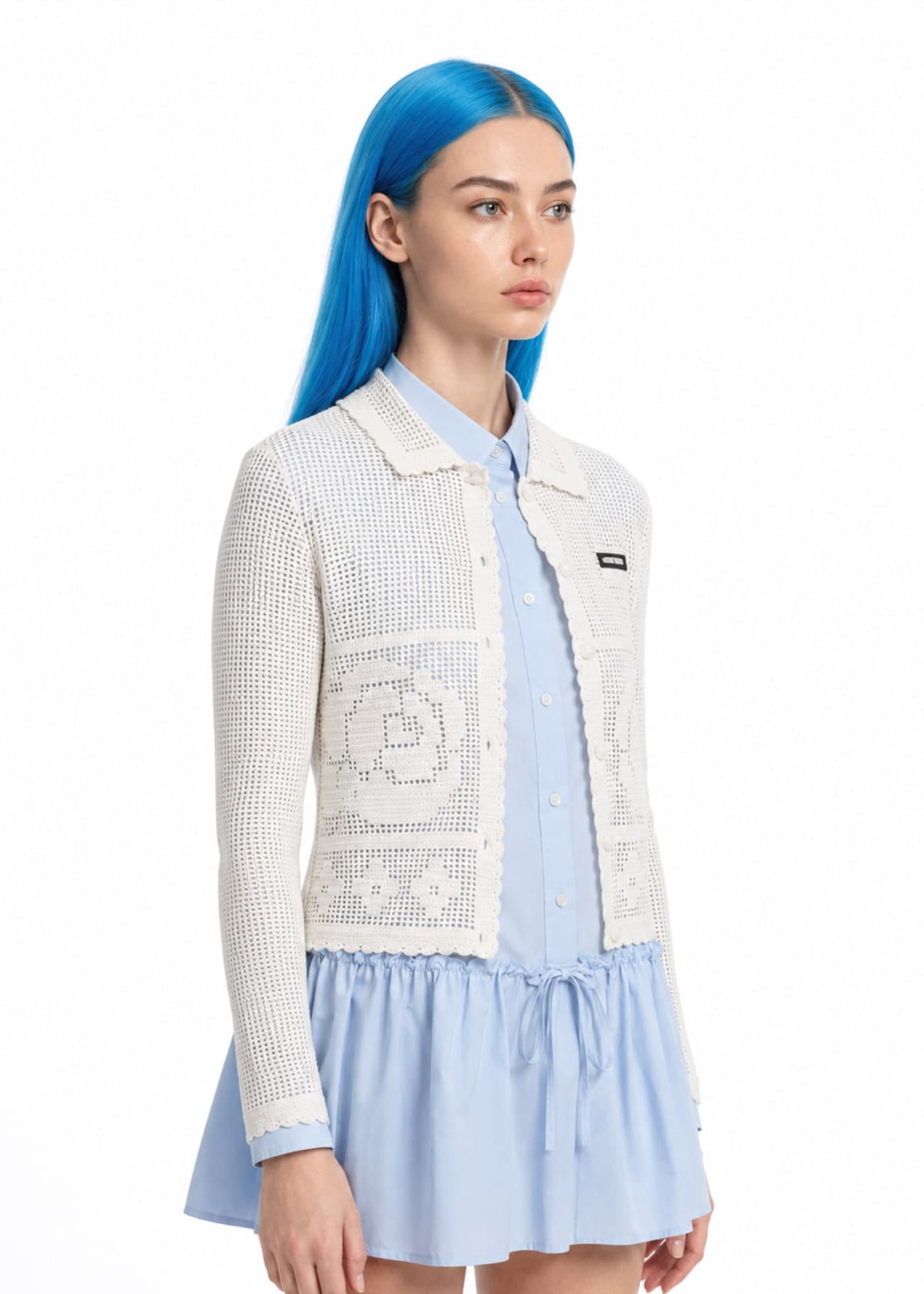 Capo indossato da un talento AI: cardigan bianco a maglia traforata su camicia azzurra, su fondo bianco.